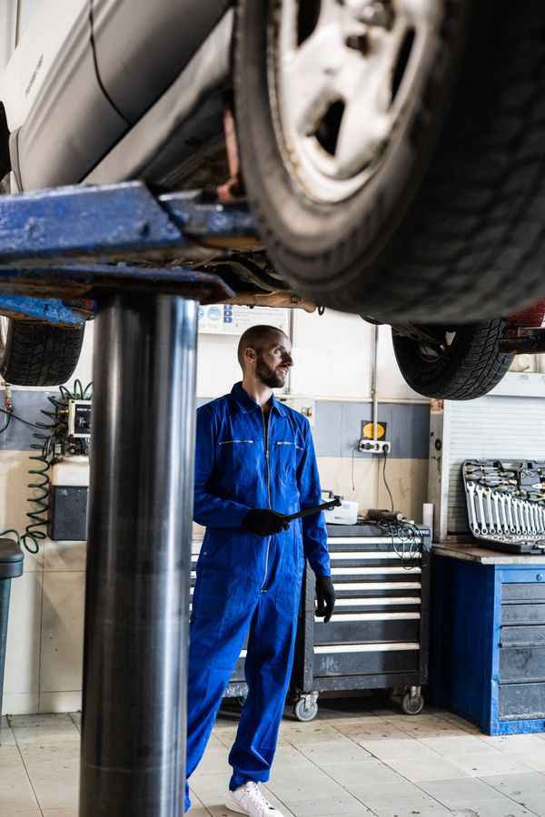 Mechanic beside a lifted vehicle