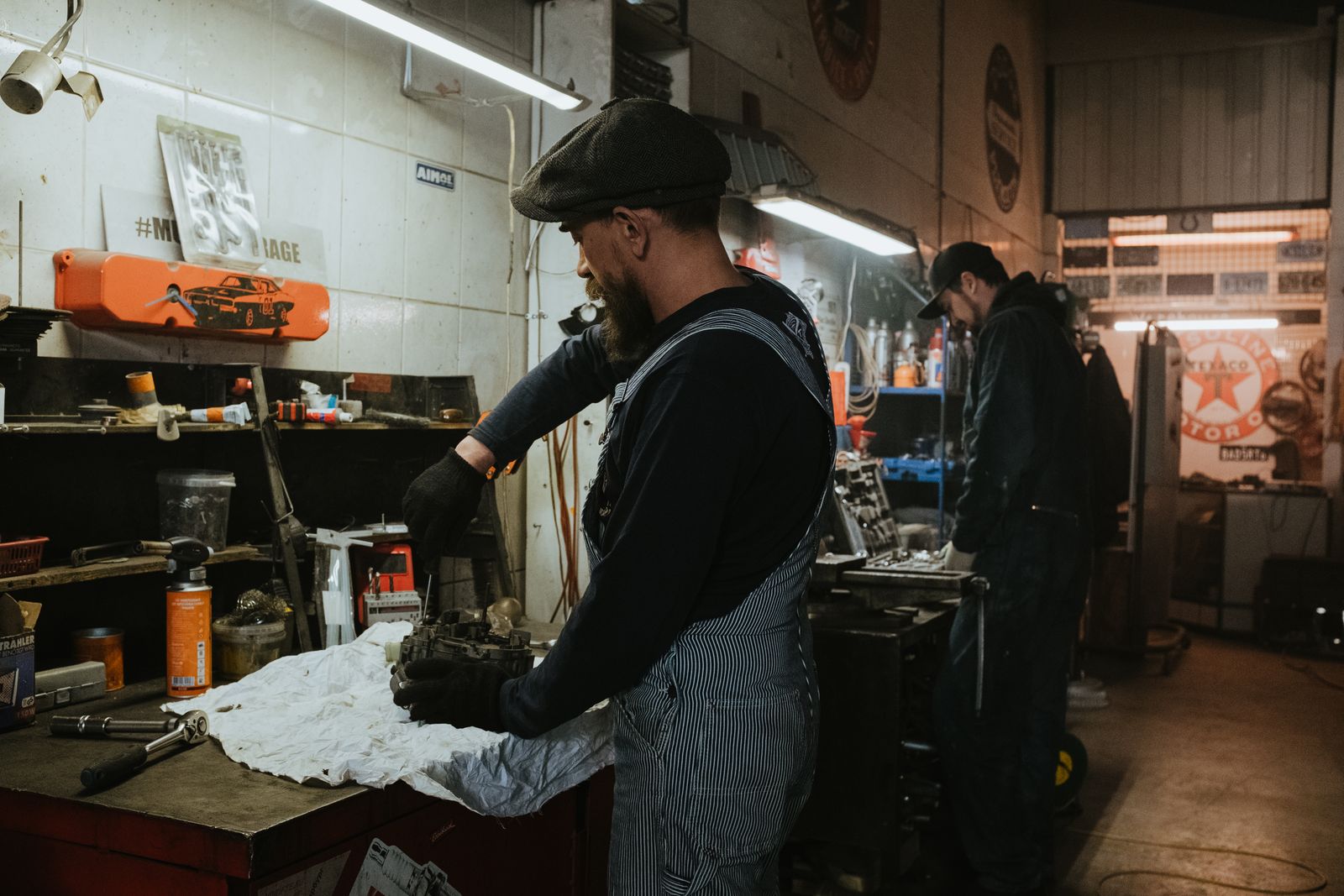 Mechanic working at a workbench inside a warmly lit garage